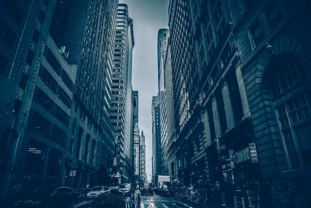 Rain-soaked city street amid towering skyscrapers